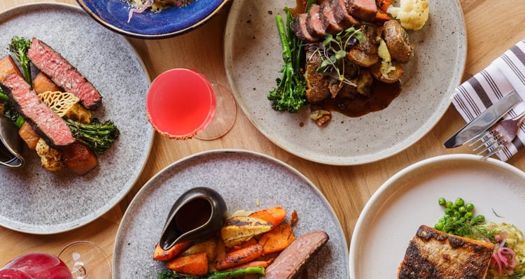 Top view of dinner entrees and drinks at Aalto