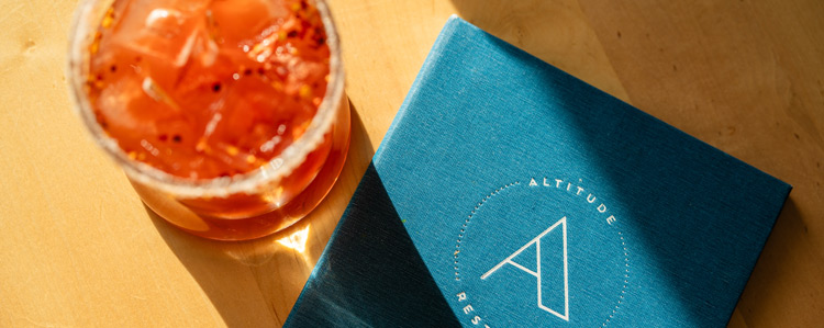 A top view of a Caesar and an Altitude menu set on a dining table.