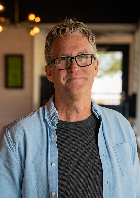 A portrait of Mike Day, wearing a blue shirt.