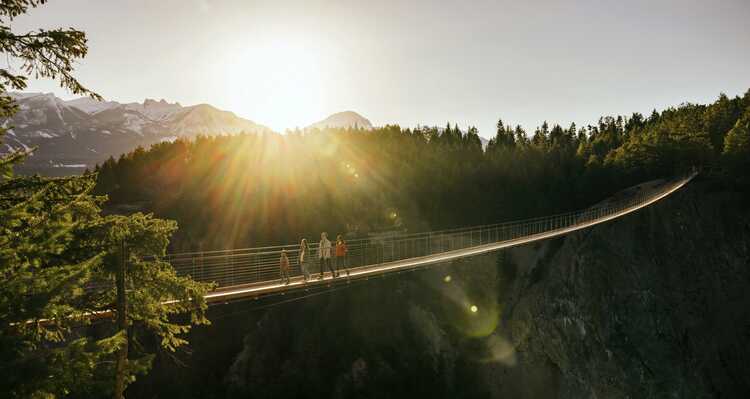 Family crossing a Skybridge during sunset