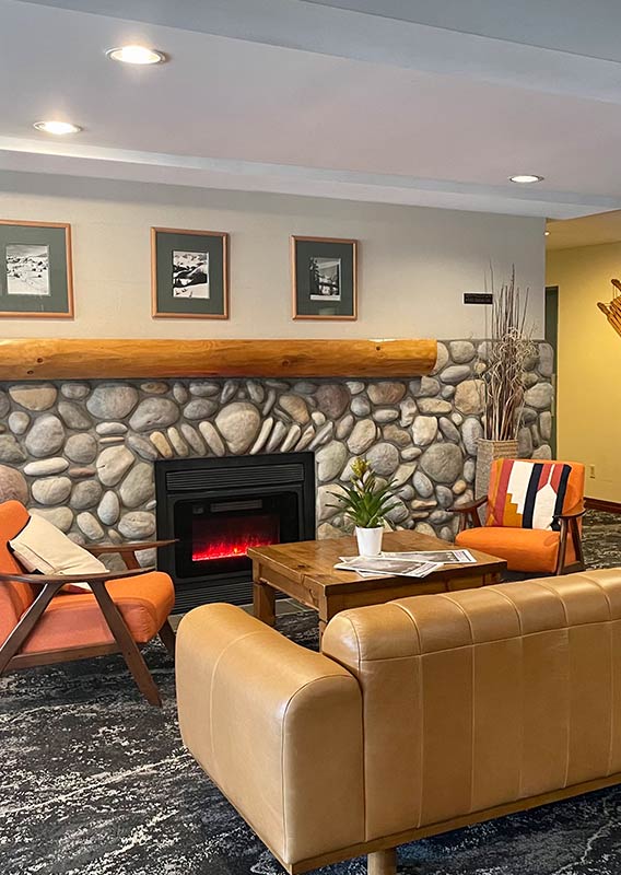 The lounge in Lobstick Lodge with chairs and fireplace