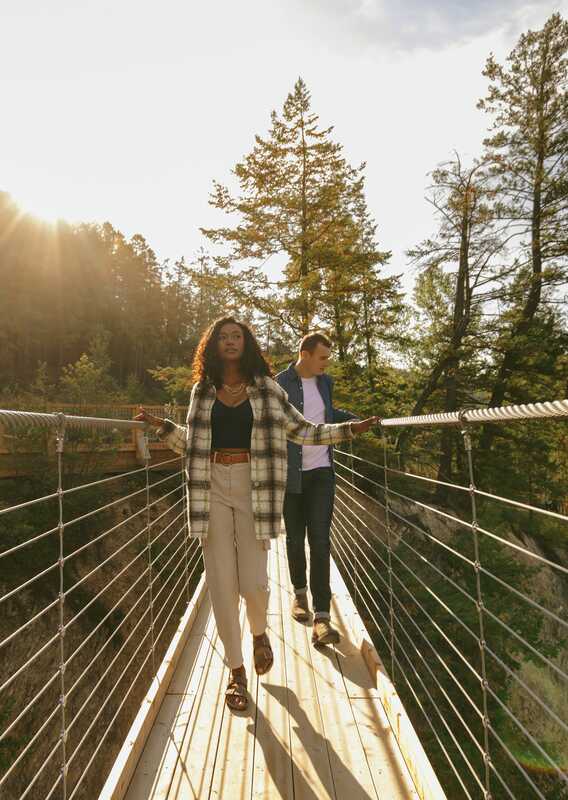 Two people walking across the Golden Skybridge at dawn