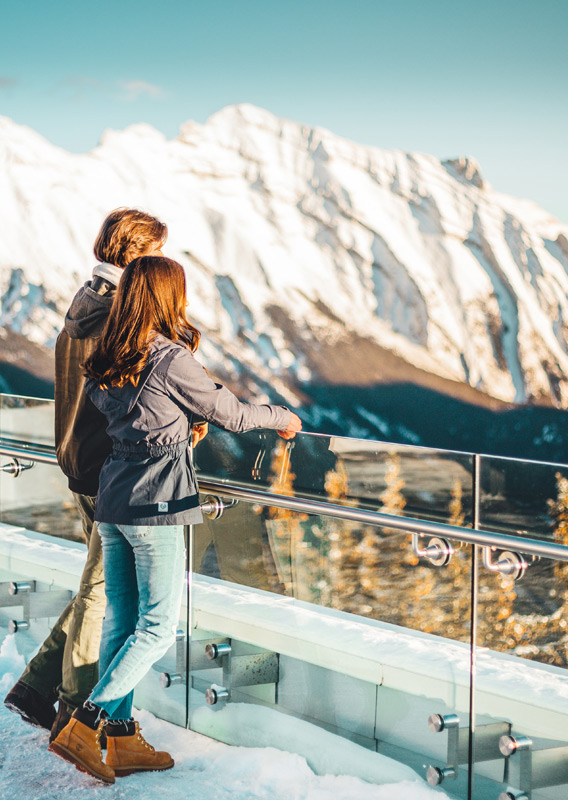 Two people looking at the mountain view from the Banff Gondola viewpoint