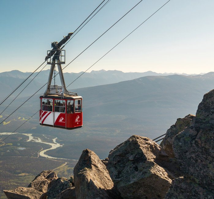 Jasper SkyTram ascending the tramway with a river and mountains in the background.