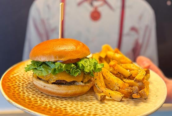 A hamburger and fries on a dinner plate.