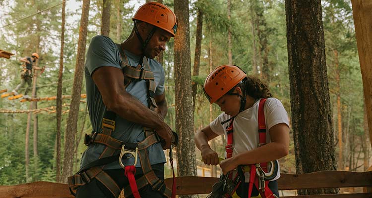 A man and girl set up their harnesses