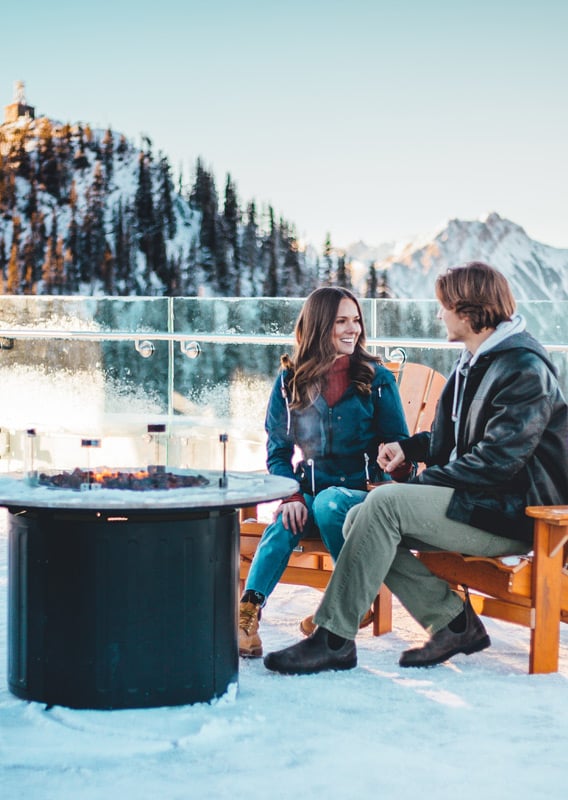 Two people sitting by the fire pit at Banff Gondola