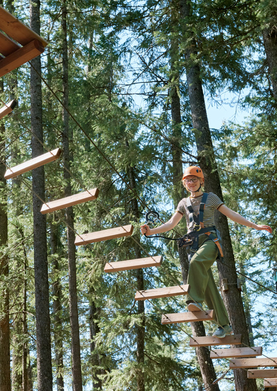 A young person climbing the Golden Skybridge Challenge Course.