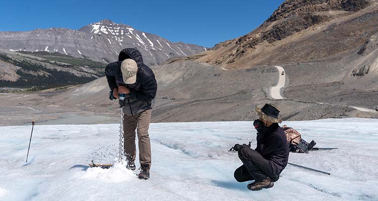 Researchers use a small drill to take ice samples from the Glacier.