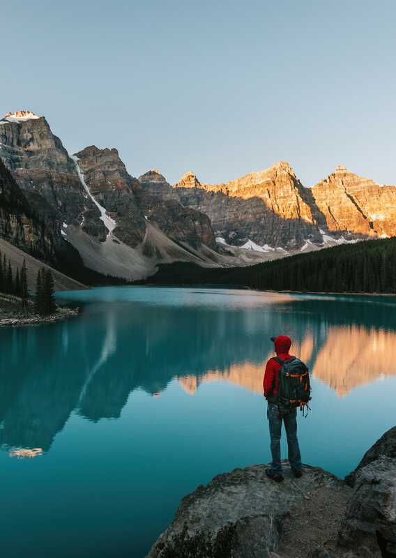 A person looking standing on a rock looking at Moraine Lake