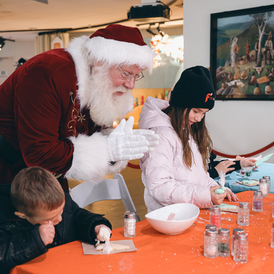 Santa decorating cookies with kids