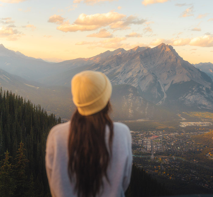 A person looking at a mountain view in the fall during golden hour.
