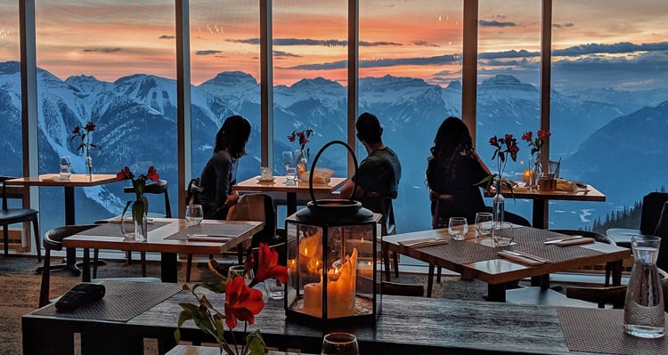 People dining at Sky Bistro and looking at the sunset and mountain view