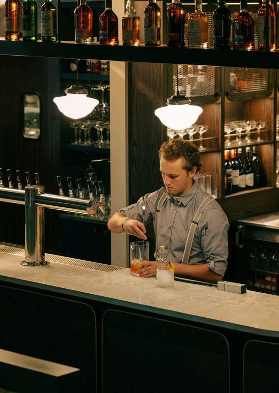 A bartender at the bar making the Smokin' Warden at Brazen