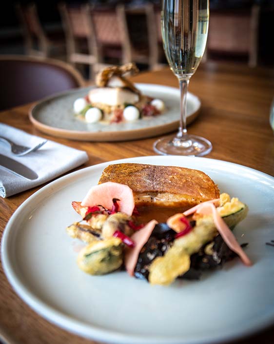 A plate of food with a champagne flute.