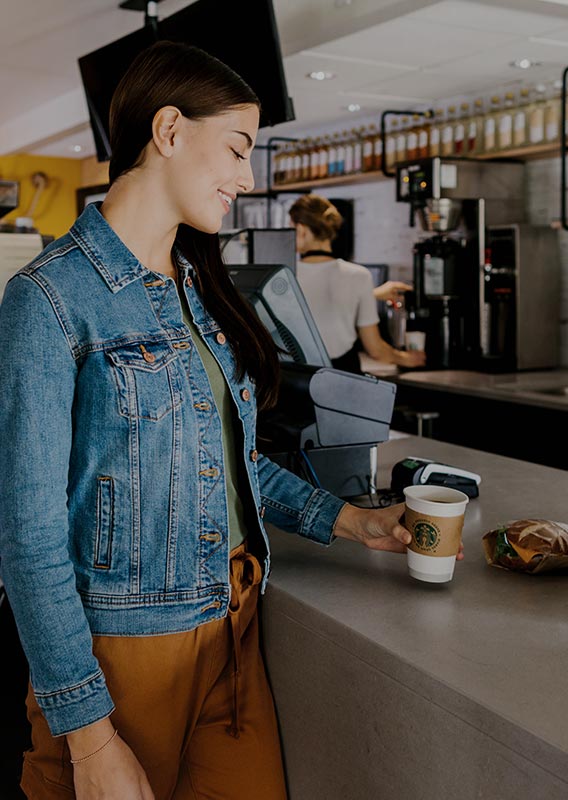 A woman picking up coffee at the Crazy Elk Cafe bartop.