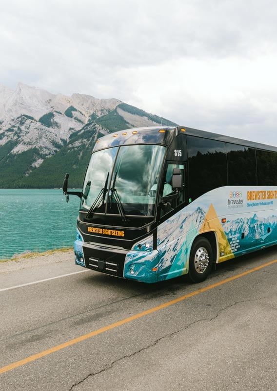 Brewster Express bus driving along highway with towering mountains