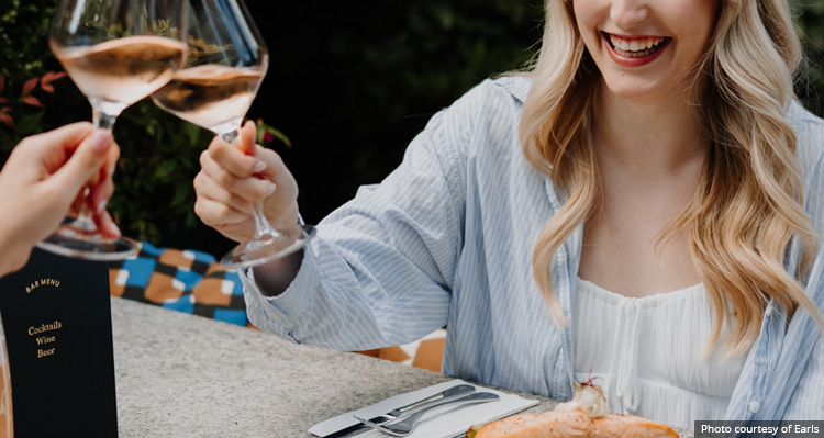 Guests toasting glasses of wine at Earls