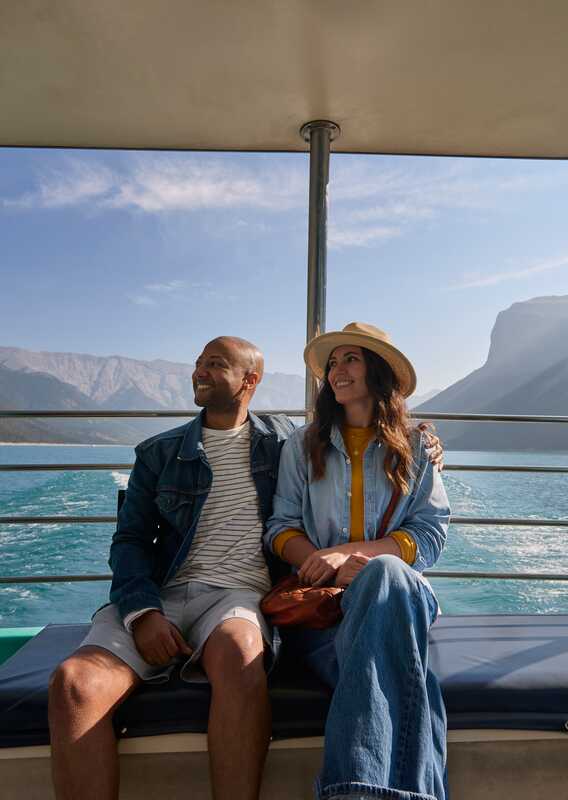 Two guests taking in the scenerty on the Lake Minnewanka Cruise in Banff, Alberta.
