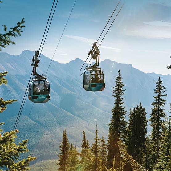 Two gondola cabins going up the mountain in winter.
