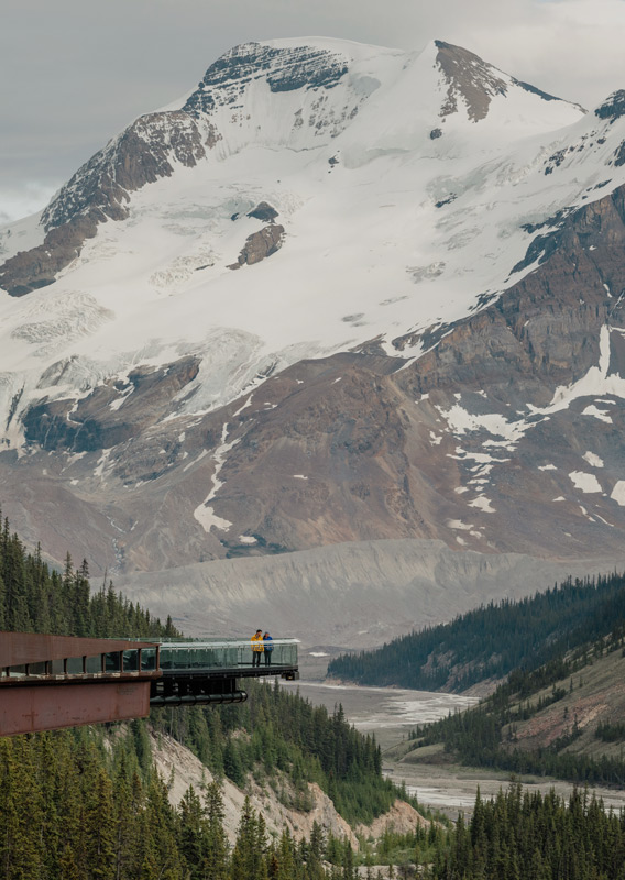 People standing on the Columbia Icefield Skywalk with a Mountain in the background