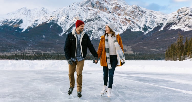 A couple skating on Pyramid Lake with Pyramid Mountain in the background