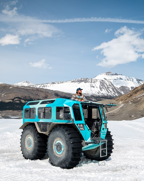 A guest looking at the view at Columbia Icefield through the sun roof of the Ice Odyssey vehicle.