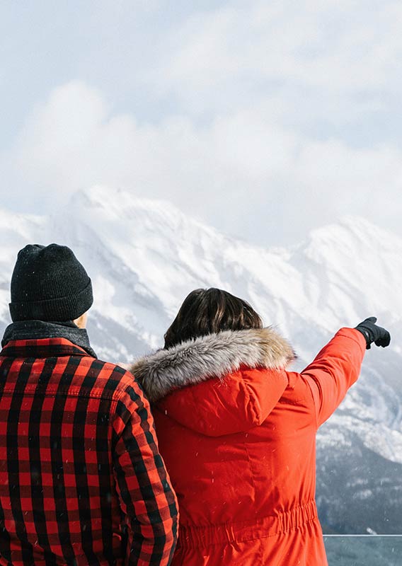 A couple pointing and looking at the view from the Banff Gondola viewpoint
