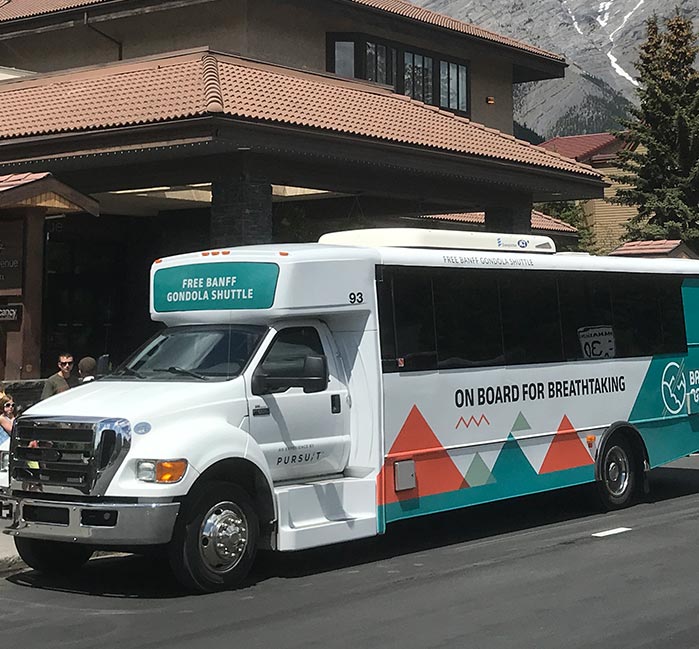 A shuttle bus stopped outside of a hotel.