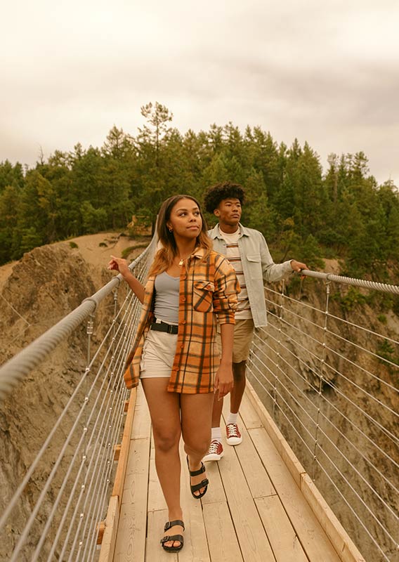 A man and woman walk along the Golden Skybridge.