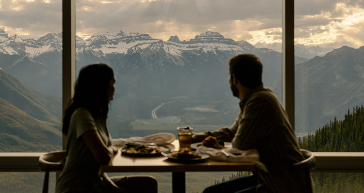 Two people dining at a hotel while looking at the mountain view