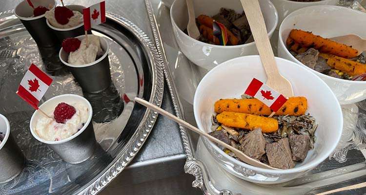 Plates of small food samples with tiny Canadian flag toothpicks.
