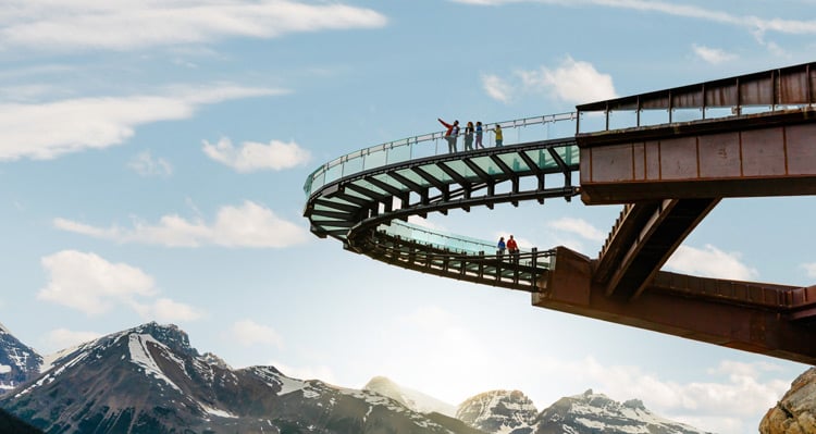 A group of people standing on the Columbia Icefield Skywalk pointing at the view