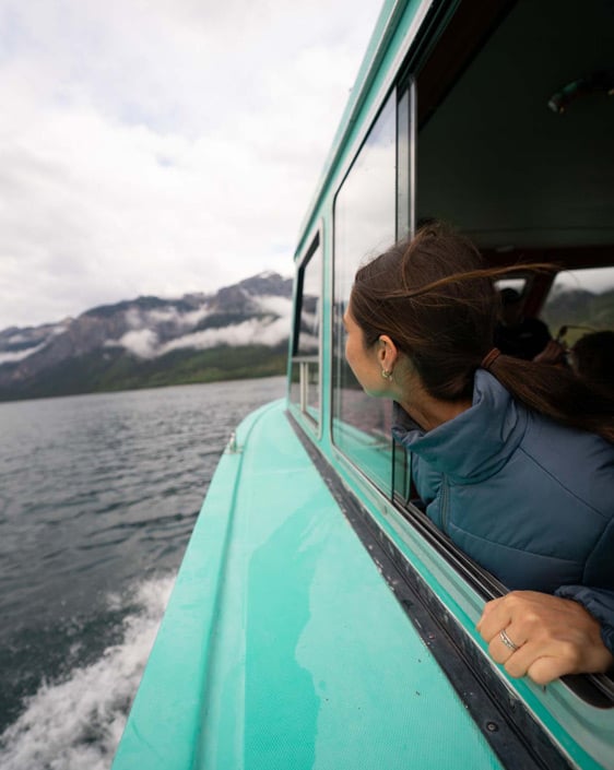 A person looking out the window during the Lake Minnewanka Cruise