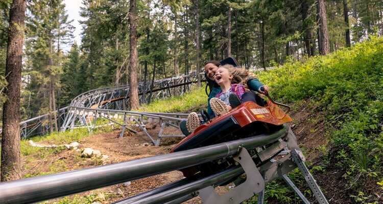 A parent and child riding the mountain roller coaster at Golden Skybridge