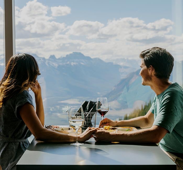 A man and woman dine at Northern Lights Alpine Kitchen and look out the window.