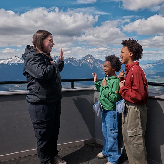 An interpretive guide leads two children in the Rockies Rangers ceremony.