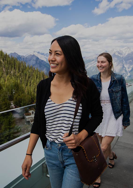 Women walk along the Banff Gondola observation deck.