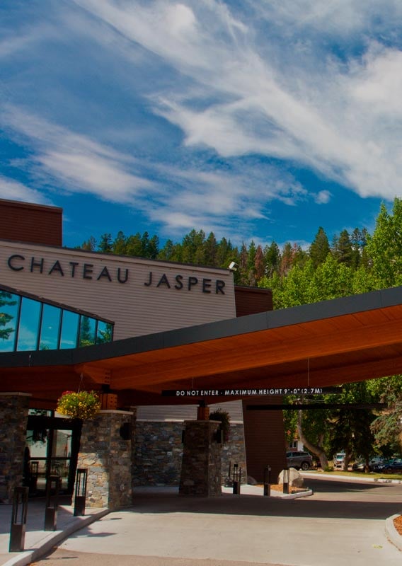 Chateau Jasper hotel entranceway with trees around the entrance