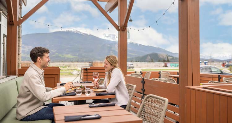 Couple dining at Terra's patio with a mountain view