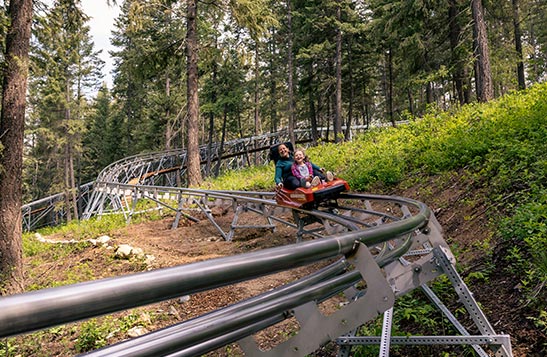 A woman and child on the Railrider Mountain Coaster.